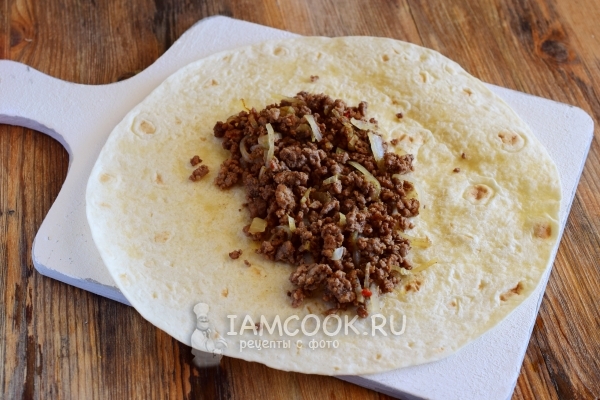 Положить фарш с луком на тортилью