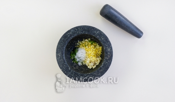 Положить в ступку чеснок, цедру, перец и соль