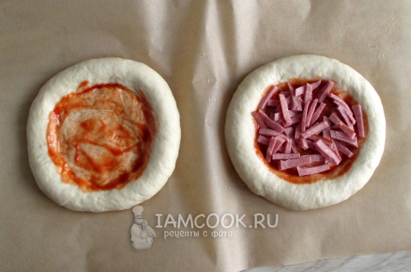 Положить на тесто соус и колбасу