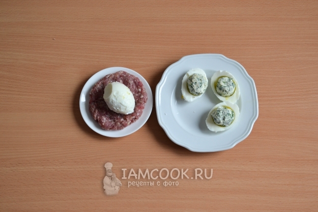 Положить на фарш яйцо