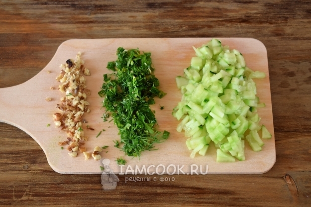 Порезать огурцы, зелень и орехи