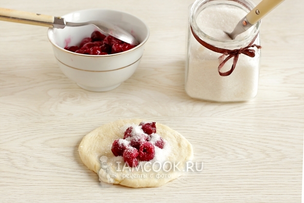 Положить на тесто малину и сахар