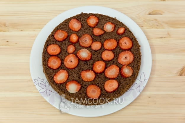 Положить клубнику на бисквит