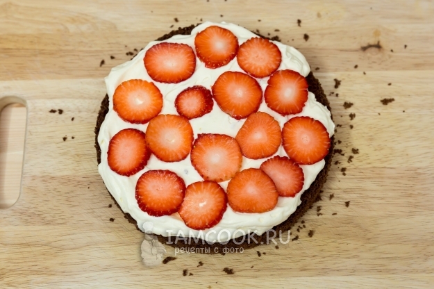 Положить на корж крем и клубнику