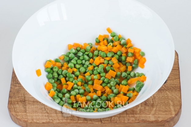 Положить в миску морковь и горошек