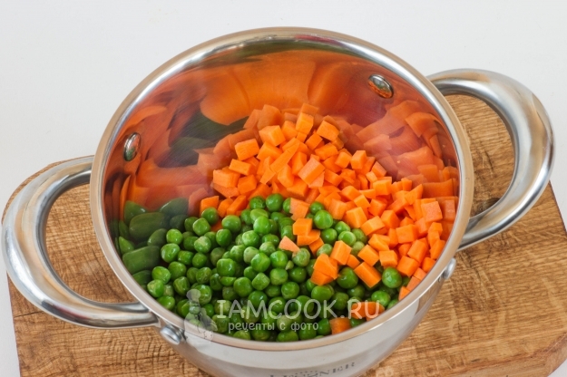 Положить в кастрюлю морковь и горошек