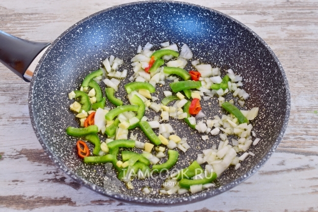 Положить лук и перец на сковороду