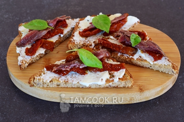 Готовые гренки с анчоусами, вялеными томатами и сливочным сыром