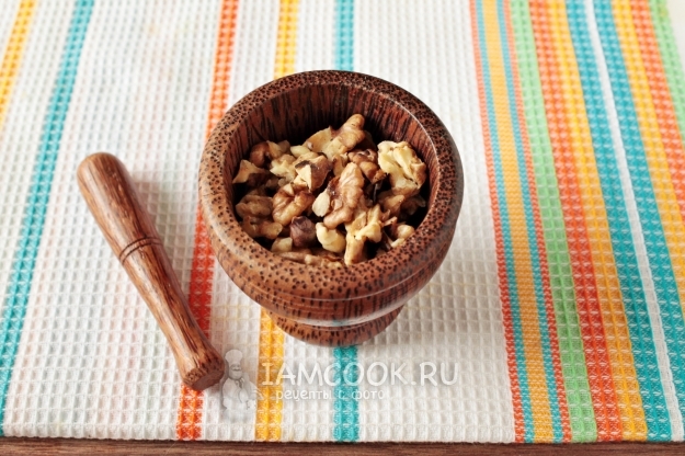 Положить орехи в ступку