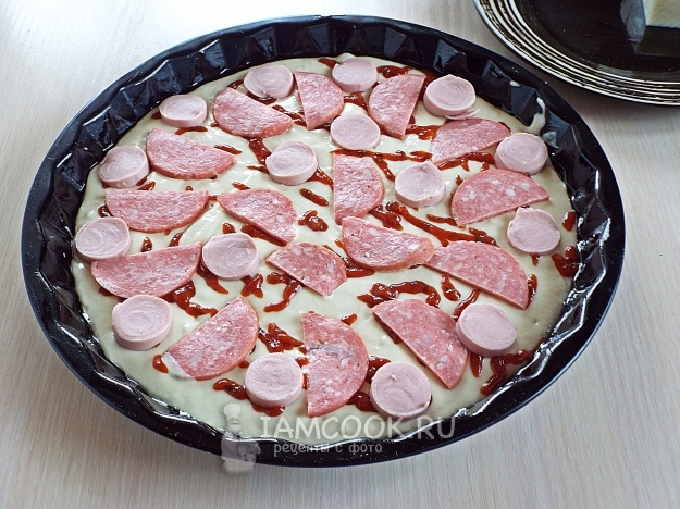 Положить на тесто колбасу