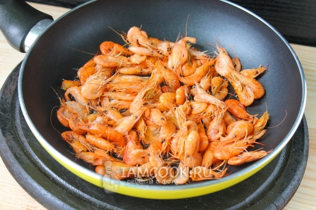 Положить креветки в сковороду