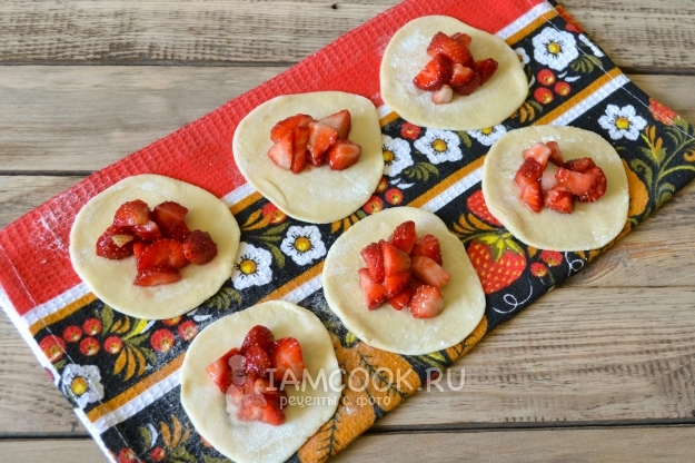 Положить на тесто клубнику