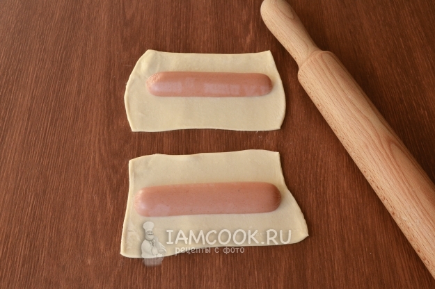 Положить сосиску на тесто