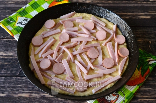 Положить на тесто колбасу