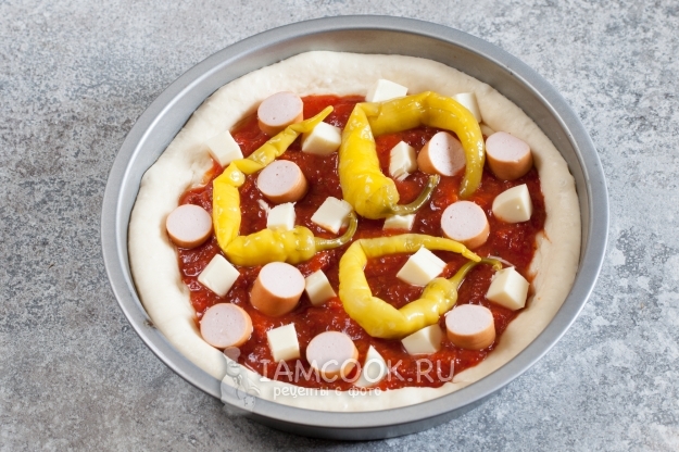 Положить на тесто соус и начинку