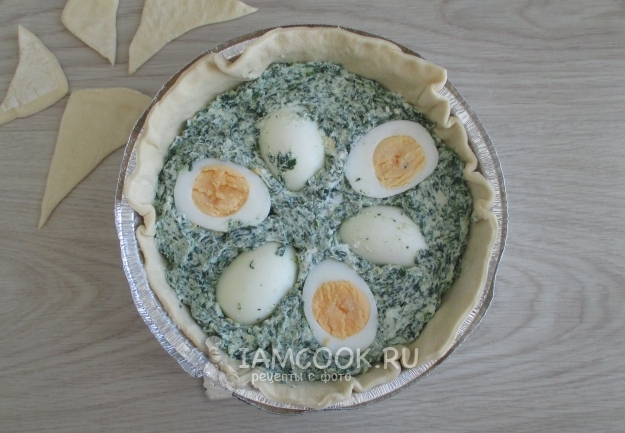 Положить на тесто шпинат и яйца