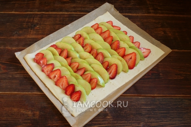 Положить клубнику и яблоки на тесто