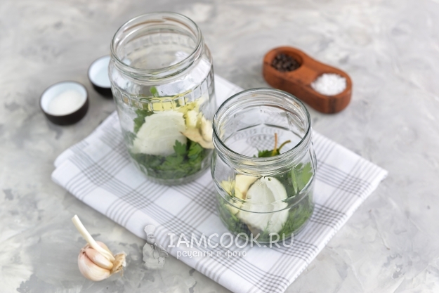 Положить в банку лук, чеснок и зелень