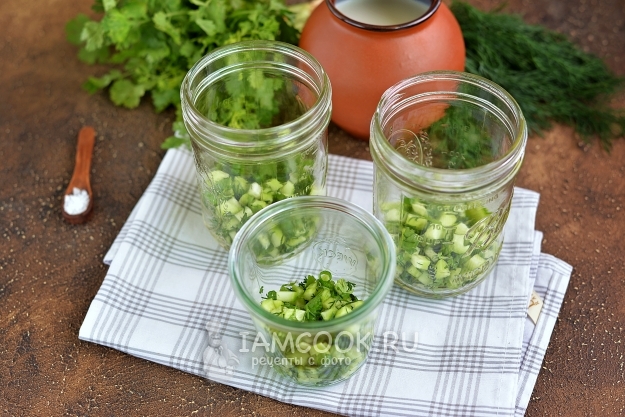 Положить огурцы с зеленью по банкам