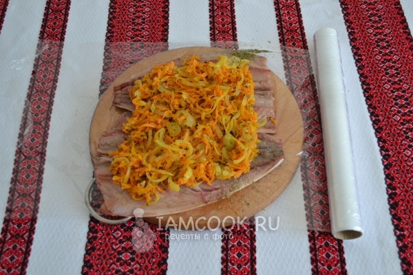 Положить на рыбу лук с морковью