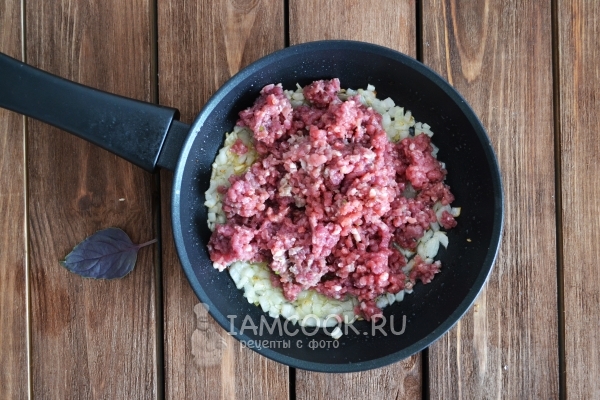 Положить фарш к луку