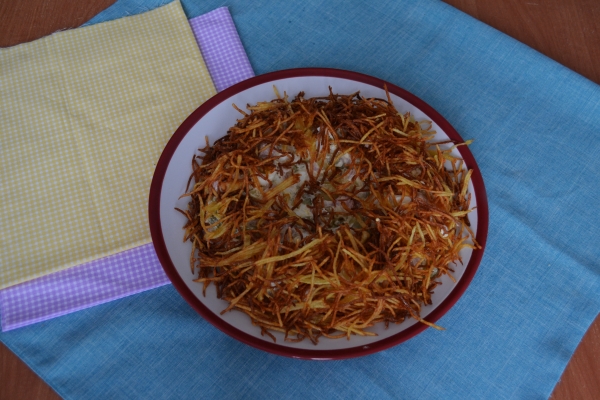 Положить на блюдо картофельную соломку