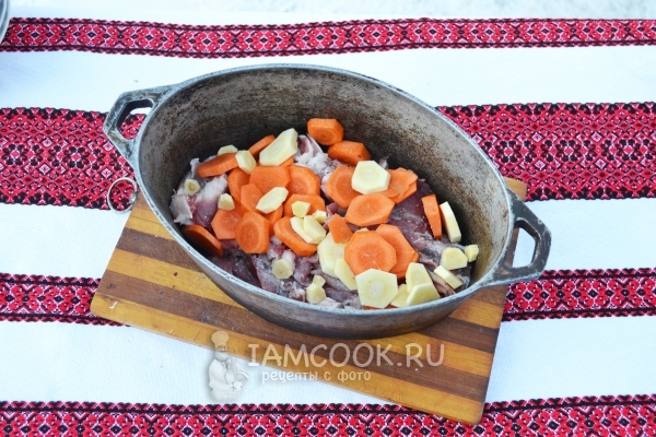 Положить в казан мясо, морковь и корень пастернака