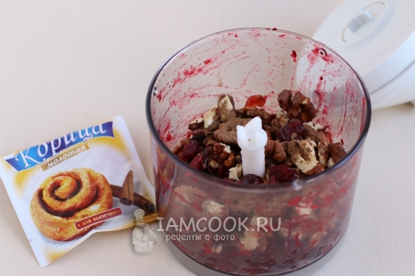 Измельчить клюкву с орехами и корицей