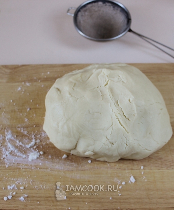 Положить тесто на доску с мукой