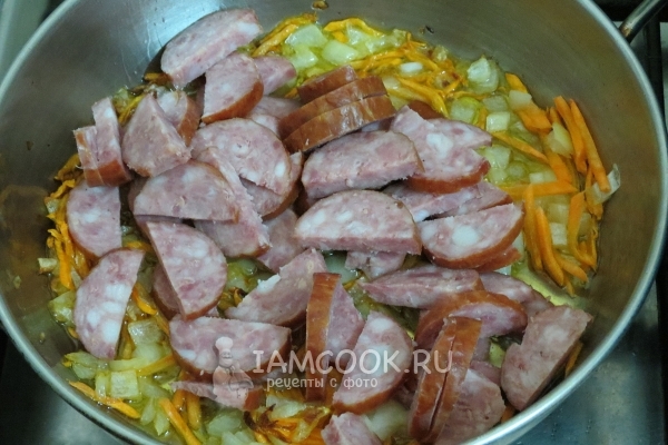 Положить колбасу к луку и моркови