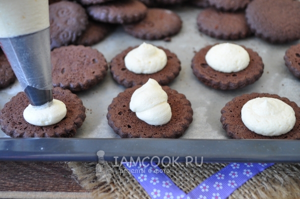 Выложить крем на печенье