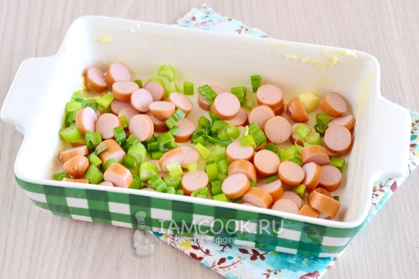 Выложить лук с колбасой в форму