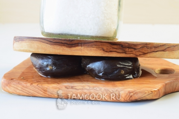 Положить баклажаны под пресс