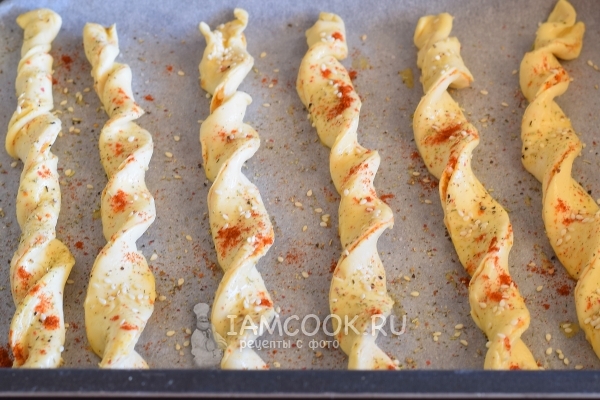 Посыпать сырные палочки специями