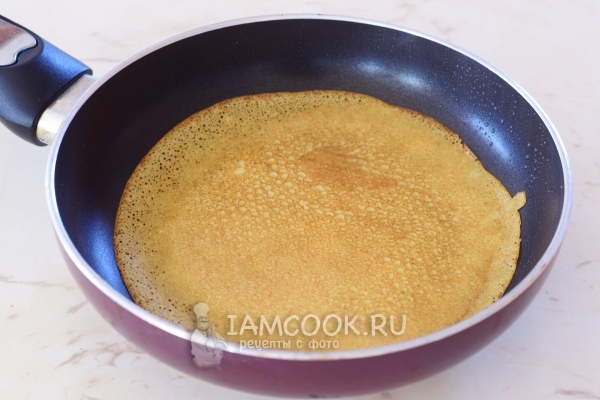 Румяный блин с дырочками на сковороде