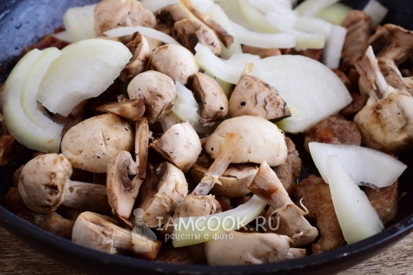 Положить к мясу лук и грибы
