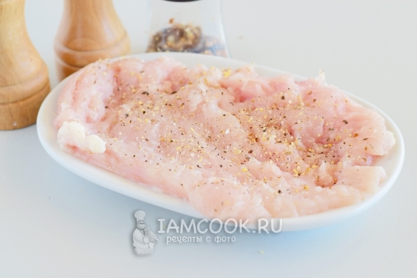 Посыпать куриную грудку солью и специями