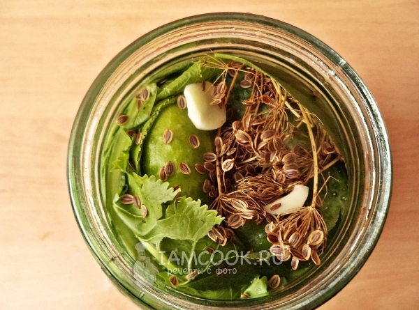 Заполнить банку огурцами, зеленью и чесноком