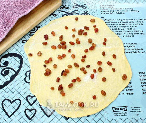 Положить на тесто изюм