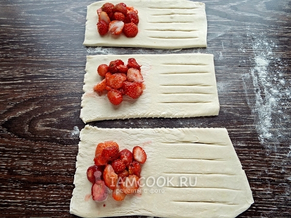 Положить на тесто клубнику