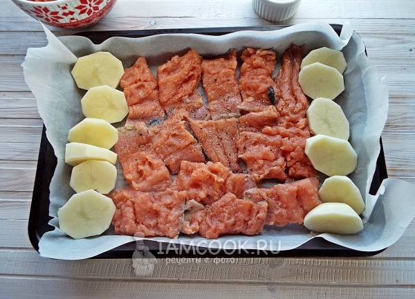 Выложить на противень рыбу и картофель