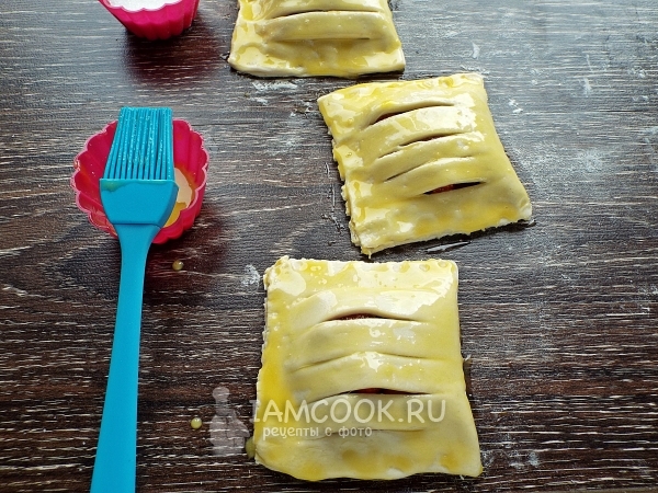 Смазать тесто слоек желтком