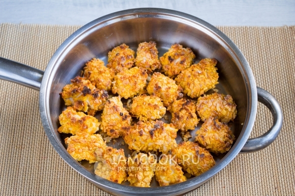 Положить куриное филе в панировке в сковороду