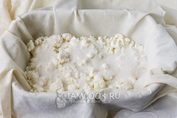 Положить на тесто творог и сахар