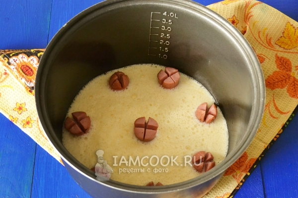 Влить яичную смесь к сосискам