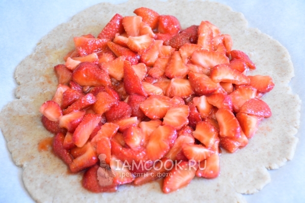 Положить на тесто клубнику