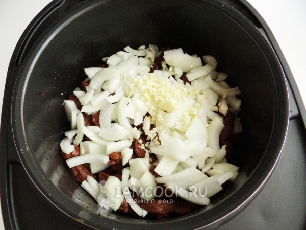 Положить к мясу лук и чеснок
