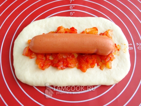 Выложили сосиску с луком на раскатанное тесто