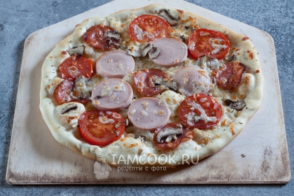 Готовая пицца с грибами, колбасой, помидорами и сыром