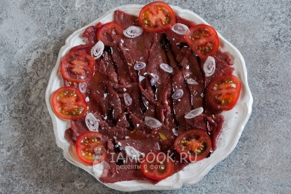 Полить мясо соусом и положить овощи